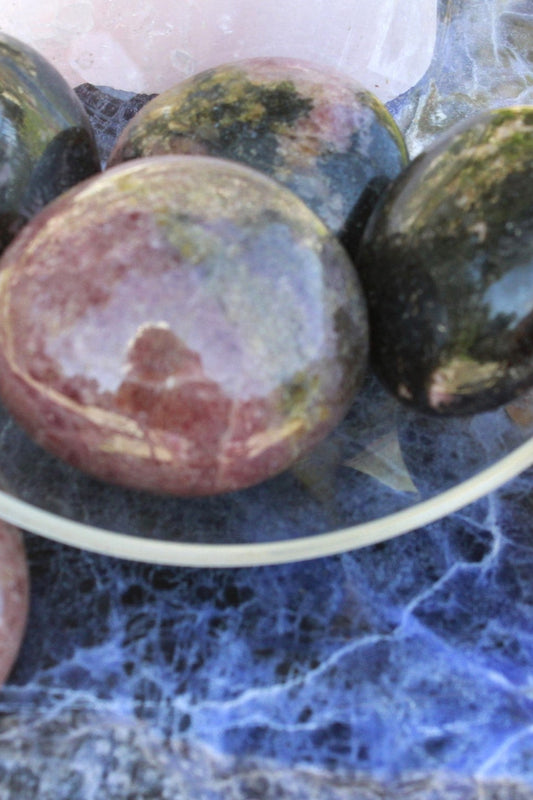 Rhodonite palm stone used for emotional healing and spiritual growth